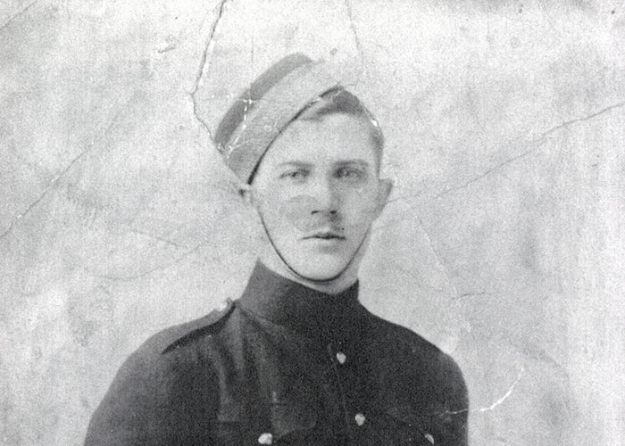 Photographie en noir et blanc d’un jeune homme portant un uniforme militaire